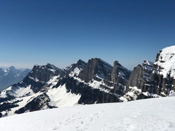 Scenic view of snowcapped mountains against clear blue sky