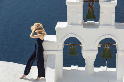Woman standing on building against sea