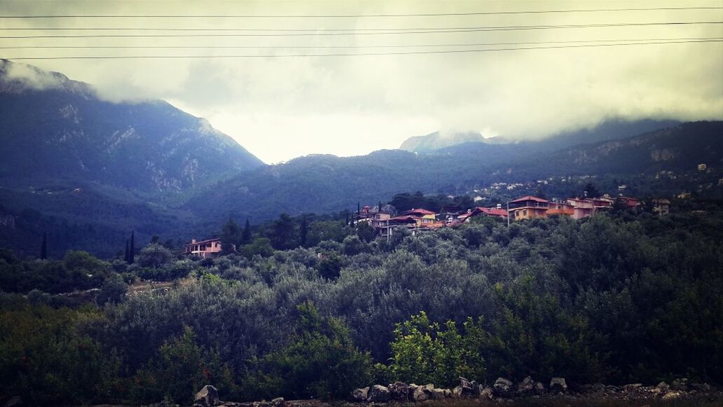 mountain, mountain range, built structure, architecture, tree, sky, building exterior, house, power line, town, nature, cloud - sky, beauty in nature, scenics, landscape, residential structure, high angle view, tranquility, tranquil scene, residential building