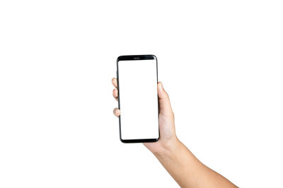 Cropped hand of woman holding mobile phone against white background