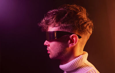 Close-up portrait of young man against black background