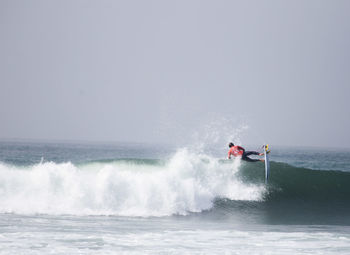 Rear view of man surfing on sea waves