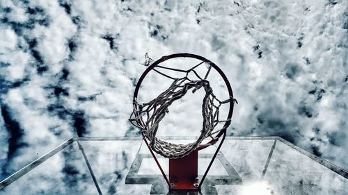 Directly below shot of basketball hoop against cloudy sky