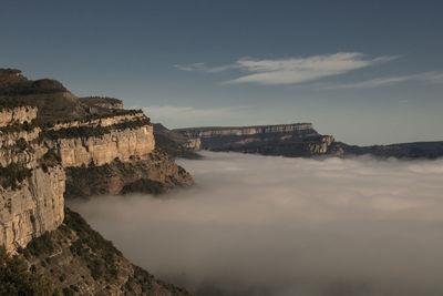 Landscape partially covered by a layer of fog under a blue sky in tavertet town in catalonia
