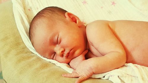 High angle view of girl sleeping on bed