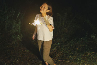 Woman standing on field at night