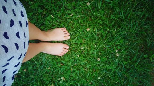 Low section of woman standing on grass