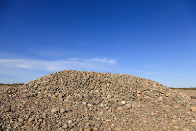 Low angle view of rocks against blue sky