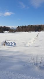 Scenic view of snowcapped field against sky