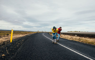 Rear view of man riding motorcycle on road