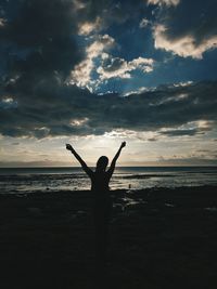 Silhouette person standing on beach against sky during sunset