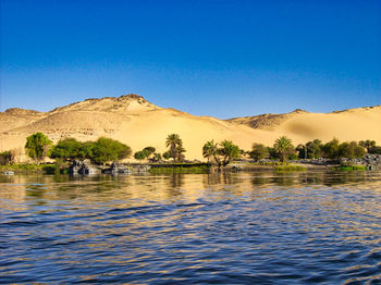 Scenic view of lake against clear blue sky