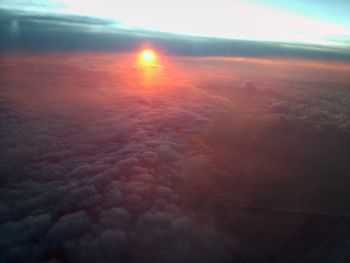 Close-up of airplane wing over cloudscape during sunset