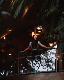 Low angle view of woman standing in balcony at night