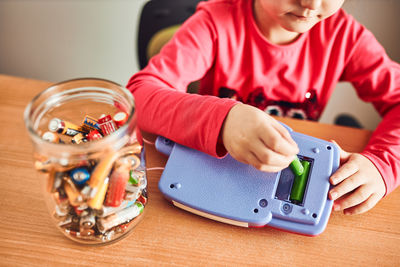 Boy holding toy car on table