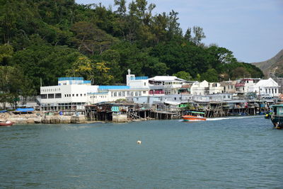 Boats moored at harbor against sky