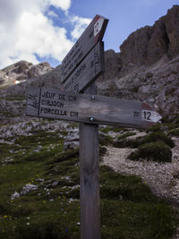 Information sign on field against sky