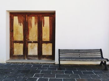 Empty bench against building