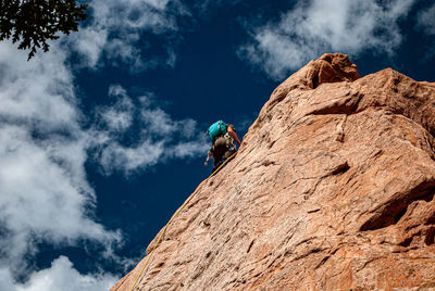 Climber belaying down a rock face