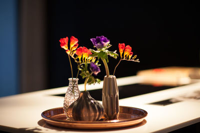 Close-up of flower vase on table against black background