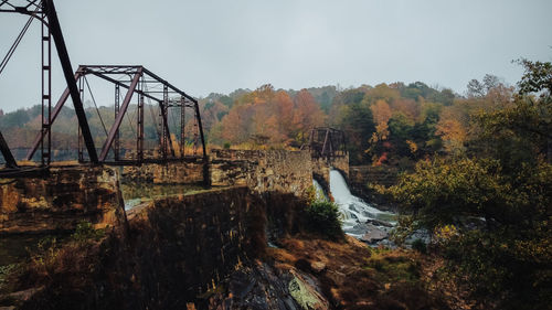 Scenic view of river in forest against sky during autumn