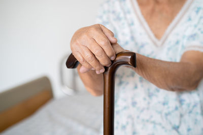 Midsection of man holding weight at home