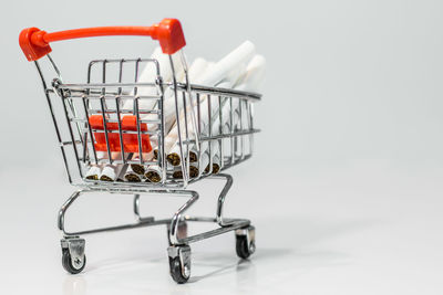 Close-up of shopping cart against white background