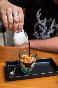 Close-up of person pouring drink in glass