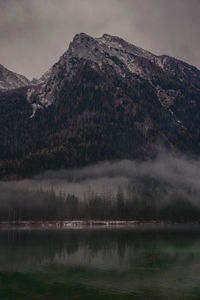 Scenic view of lake by mountain against sky