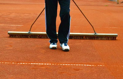 Low section of man cleaning sports field