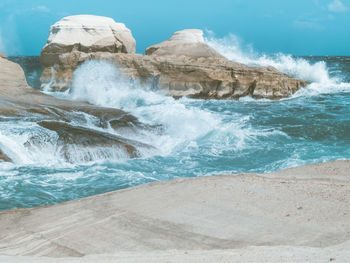 Scenic view of rocks on beach against sky