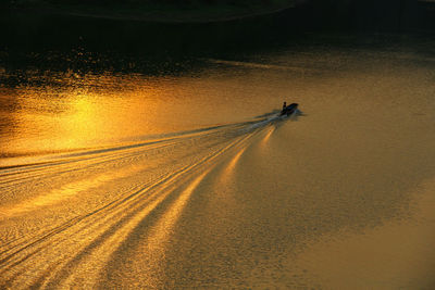 High angle view of speedboat moving in river during sunset