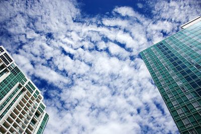 Low angle view of modern building against cloudy sky