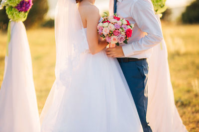 Side view of couple holding flower bouquet