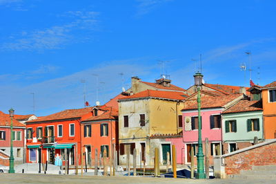 Buildings in city against blue sky