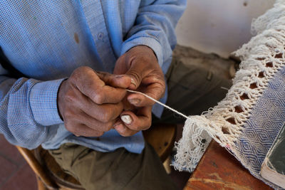 Midsection of man holding fabric at home