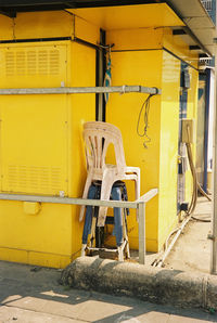 Empty chairs against yellow wall