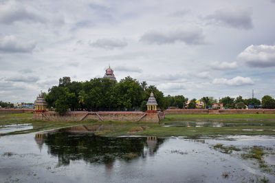 Scenic view of lake by building against sky