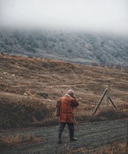 Rear view of man on land against sky