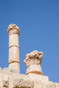 Low angle view of old ruins against clear blue sky