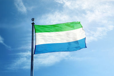 Low angle view of flag against blue sky