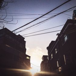 Low angle view of silhouette electricity pylon against sky