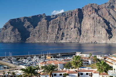 High angle view of townscape by sea against sky