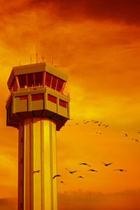Birds flying over sea against romantic sky at sunset