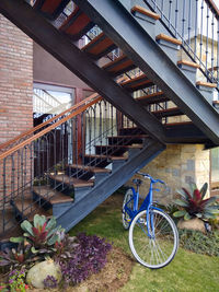 Bicycle parked by staircase against building