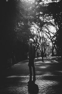 Full length of man standing on road against trees