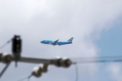 Close-up of airplane flying against blue sky