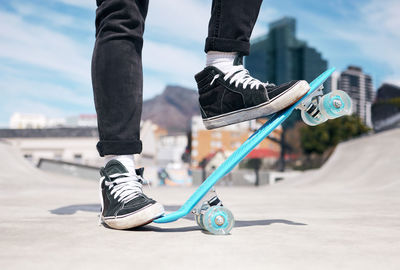 Low section of man skateboarding on road