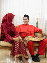 Couple in traditional clothing sitting on sofa at home