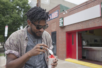 A young man eating frozen yoghurt.